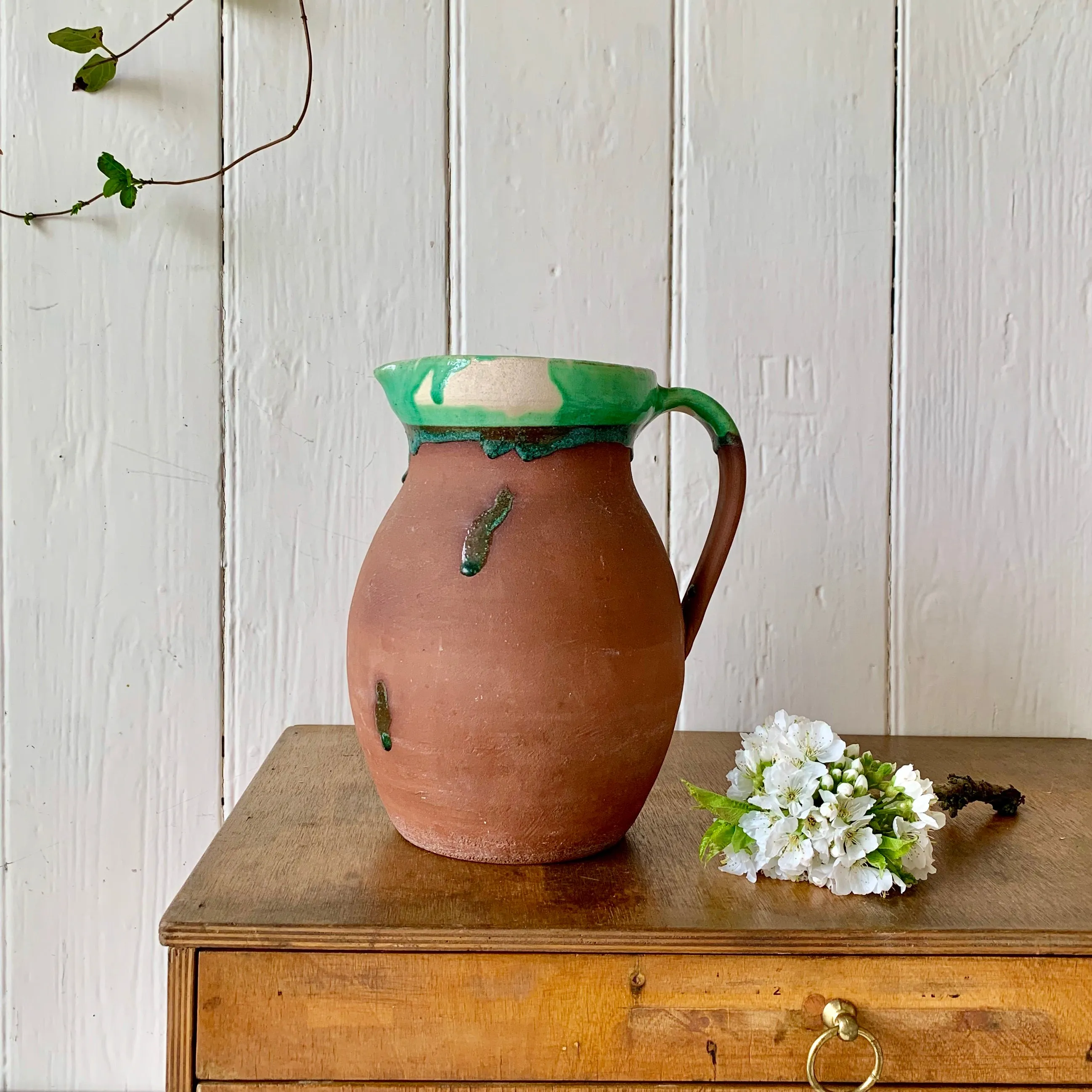 Large antique terracotta jug with green slip glazed rim