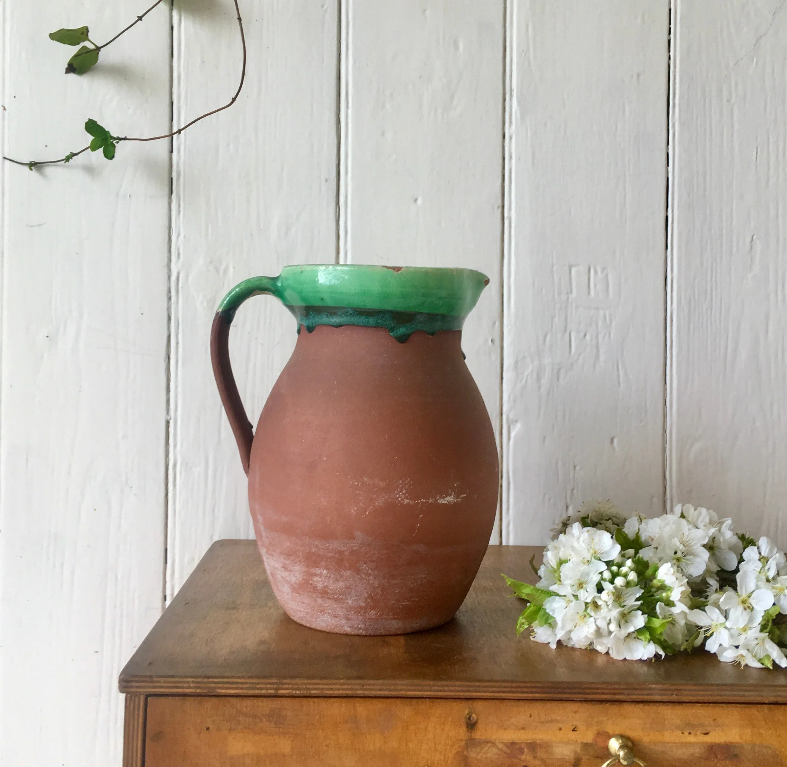 Large antique terracotta jug with green slip glazed rim